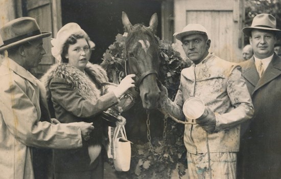 Travtræner Poul Stripp med pokalen i hånden efter Jollys sejr i Dansk Trav Derby 1948. Han flankeres af de tre ejere - f.v. slagtermester Børge Johansen og frue samt benzinforhandler Karl Götke.